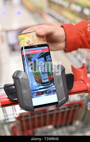 Köln, Deutschland. 10 April 2019, Nordrhein-Westfalen, Köln: Zu Korr für das Einkaufen mit dem Handy von Erich Reimann. Kunden Handy scannt die Waren beim Einkaufen in einem Rewe Center. Foto: Henning Kaiser/dpa Quelle: dpa Picture alliance/Alamy leben Nachrichten Stockfoto