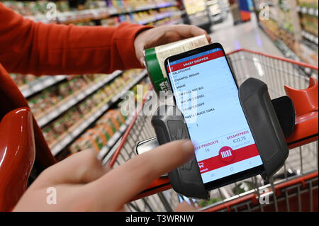 Köln, Deutschland. 10 April 2019, Nordrhein-Westfalen, Köln: Zu Korr für das Einkaufen mit dem Handy von Erich Reimann. Kunden Handy scannt die Waren beim Einkaufen in einem Rewe Center. Foto: Henning Kaiser/dpa Quelle: dpa Picture alliance/Alamy leben Nachrichten Stockfoto