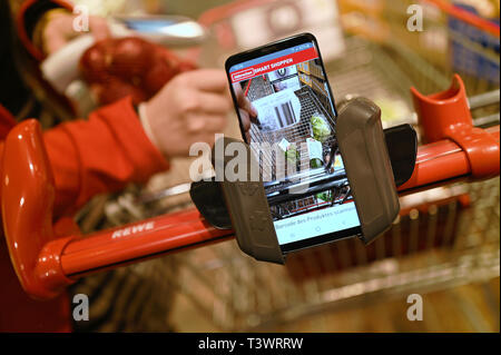 Köln, Deutschland. 10 April 2019, Nordrhein-Westfalen, Köln: eines Kunden Handy scannt die Waren beim Einkaufen in einem Rewe Center. Foto: Henning Kaiser/dpa Quelle: dpa Picture alliance/Alamy leben Nachrichten Stockfoto