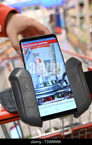 Köln, Deutschland. 10 April 2019, Nordrhein-Westfalen, Köln: Zu Korr für das Einkaufen mit dem Handy von Erich Reimann. Kunden Handy scannt die Waren beim Einkaufen in einem Rewe Center. Foto: Henning Kaiser/dpa Quelle: dpa Picture alliance/Alamy leben Nachrichten Stockfoto