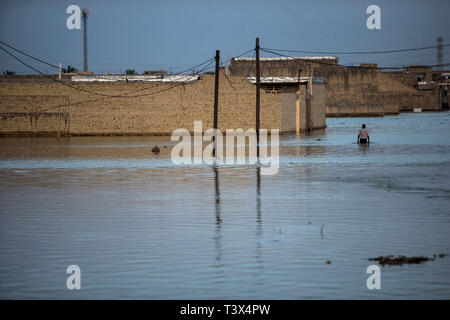 (190412) - AHVAZ, April 12, 2019 (Xinhua) -- ein Mann watet durch Hochwasser vor den Toren der Stadt Ahvaz, der Hauptstadt der Provinz Khuzestan, Iran, 11. April 2019. (Xinhua / Ahmad Halabisaz) Stockfoto