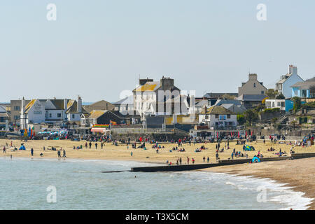 Lyme Regis, Dorset, Großbritannien. 12. April 2019. UK Wetter. Urlauber am Strand warm eingepackt die Frühlingssonne an einem kühlen Badeort von Lyme Regis in Dorset während der Osterferien Schulferien zu genießen. Foto: Graham Jagd-/Alamy leben Nachrichten Stockfoto