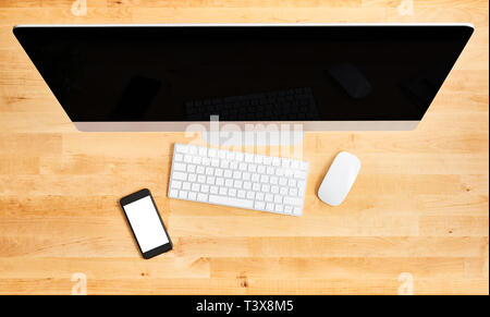 Desktop Computer Ansicht von oben. Blick von oben auf die hölzernen Schreibtisch mit großen Desktop Computer, Tastatur, Maus und Smartphone. All-in-One Computer. Moderne wor Stockfoto