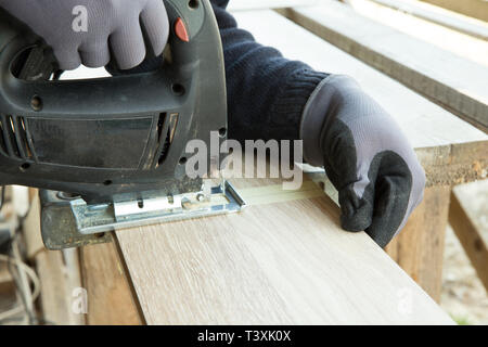 Mann Verlegung Laminatboden in Baukonzept. Konstruktion, Reparaturkonzept. Stockfoto