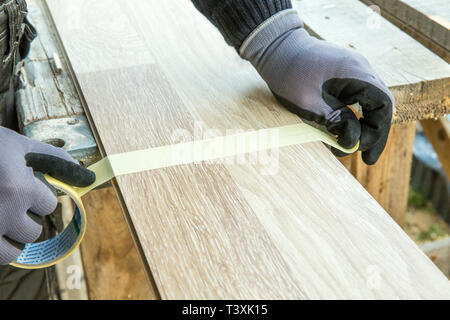 Mann Verlegung Laminatboden in Baukonzept. Konstruktion, Reparaturkonzept. Stockfoto