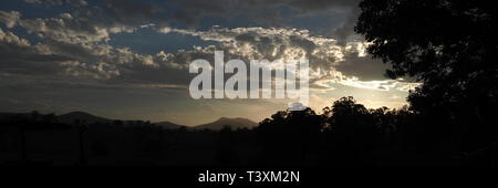 Sonnenuntergänge. Schönen Sonnenuntergang mit Schattenrissen von Bäumen. Wolken im Himmel. Stockfoto