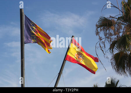 Zwei große Fahnen des spanischen Staates und der Autonomen Region Valencia an einem sonnigen Tag am Strand und die Royal Marina im Hafen von Valencia. Stockfoto