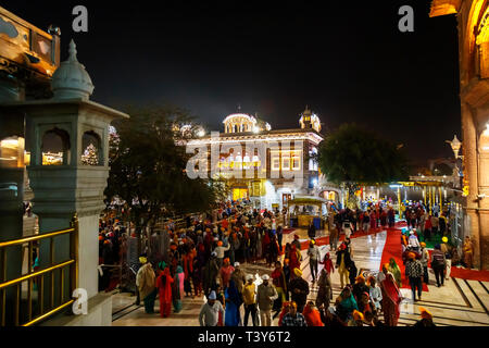 Lokale Sikhs Queuing auf dem Damm der Sanctum Sanctorum der Goldenen Tempel von Amritsar, dem heiligsten Wallfahrtsort des Sikhismus, Punjab eingeben Stockfoto