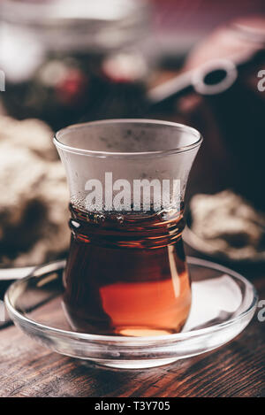 Armudu Glas mit schwarzer Tee mit Küchenutensilien auf Hintergrund Stockfoto