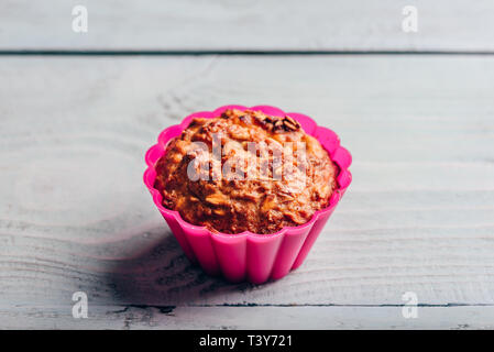 Gekochte Haferflocken Muffin in einem rosa Silikon Backformen über hellen Hintergrund. Stockfoto