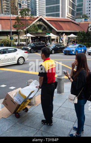 29.03.2019, Singapur, Republik Singapur, Asien - eine DHL Lieferung Kerl wartet an einer Ampel im Central Business District. Stockfoto