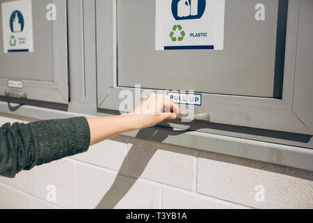 Eine Person öffnet oder schließt eine moderne Abfallbehälter für die getrennte Sammlung von Abfällen. Stockfoto