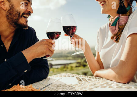 Schuss ein glückliches Paar in einem Restaurant sitzen, zusammen mit einem Glas Rotwein 7/8. In der Nähe von ein Paar auf einem Datum und Zeit reden wit Stockfoto