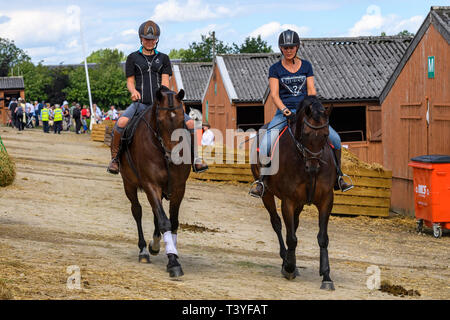 Weibliche Teilnehmer in der Pferdeartigen Klasse tragen, Hüte, Pferde im Stall Hof, Aufwärmen vor dem Wettbewerb - Tolle Yorkshire, England, Großbritannien Stockfoto