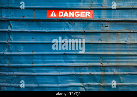 Warnschild auf dem roten Klebeband über grungy blau Metall Wand Stockfoto