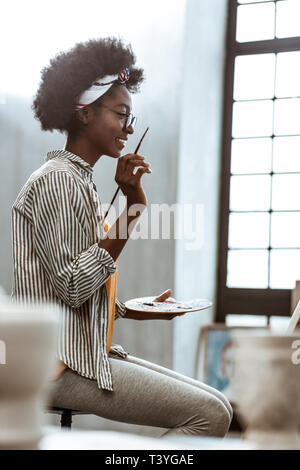 Mit der Arbeit zufrieden. Die Übertragung der internationalen Kunst student zufriedenen Gefühl mit ihrer Arbeit nach dem Lackieren Stockfoto