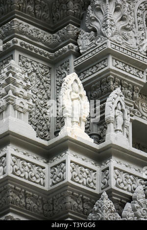 Weiße statue hebt sich von den Grauen umgebenden Gravuren und Statuen auf der Ecke des Stupa Kantha Bopha am Königspalast in Phnom Penh. Stockfoto