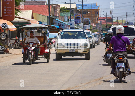 Motorräder, Autos und ein remorque (Tuk Tuk) reisen auf den Straßen von Phnom Penh, Kambodscha an einem heißen Sommertag. Stockfoto