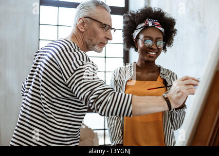 Malerei Resin. Fröhliche junge Frau Gefühl erstaunliche während der Teilnahme an interessanten Malerei Masterclass Stockfoto
