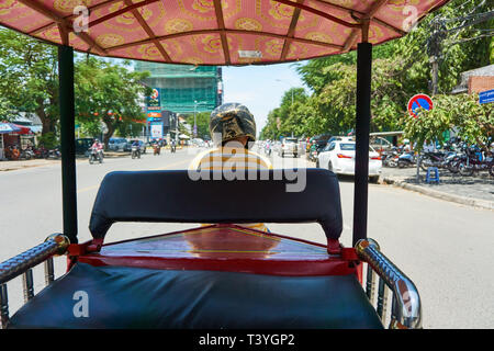 Einen behelmten Fahrer ein remorque (kambodschanisches Tuk-Tuk von einem Motorrad gezogen) auf der Straße in Phnom Penh, Kambodscha. Stockfoto