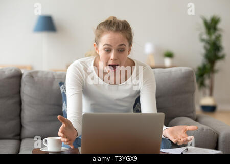 Schockiert Frau mit weit offenen Augen Blick auf Laptop Bildschirm Stockfoto