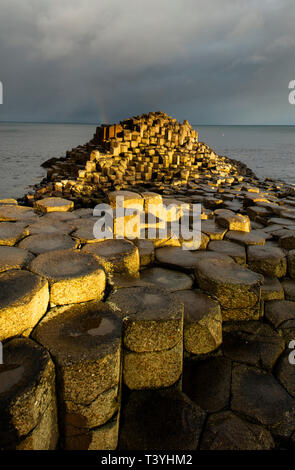 Nordirland, Land, Antrim, Giant's Causeway. Regenbogen hinter dem Sechseckigen basalt Felsformationen des, Stuhl, Teil des riesigen caus Stockfoto