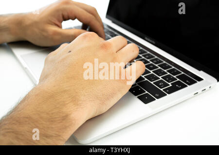 Business Person über die Tastatur eines Laptops auf einem weißen Tisch. Person, die die Arbeit in einem Büro. Stockfoto