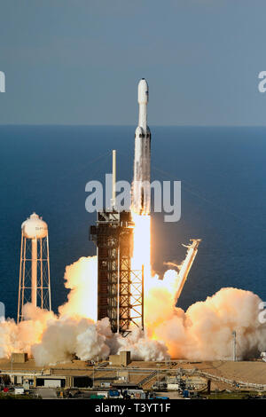 Eine SpaceX Falcon 9 Heavy Rakete hebt ab um 6:35 Uhr auf dem Kennedy Space Center, Florida am 11. April. 2019. Die Rakete ist die Steigerung der Arabsat 6 Satel Stockfoto