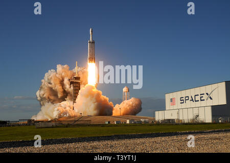 Eine SpaceX Falcon 9 Heavy Rakete hebt ab um 6:35 Uhr auf dem Kennedy Space Center, Florida am 11. April. 2019. Die Rakete ist die Steigerung der Arabsat 6 Satel Stockfoto