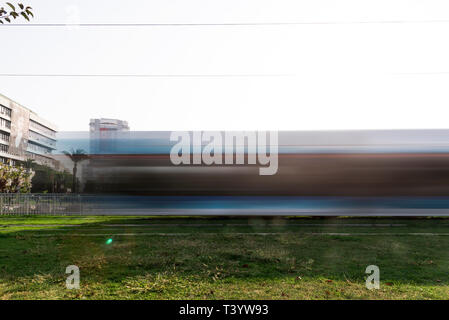 Izmir, Türkei - 10. November 2018: Lange Belichtung Foto von Izmir Straßenbahn auf der Bahn mit Gras. Die Straßenbahn ist Bewegung verwischt. Stockfoto