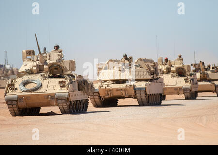 Eine Gruppe von Bradley Kampffahrzeugen und M1 Abrams Kampfpanzer an 2nd Brigade Combat Team zugeordnet, 1. Panzerdivision, gehen Sie in einer Linie auf dem Weg zu ihrem Ziel während der Übung Streik konzentrieren, um orogrande Bereich Lager, N.M., April 8, 2019. Streik Focus ist ein vielschichtiges und multi-Woche lange Übung, die zahlreichen operativen Aspekte einer Brigade Combat Team in einem geschlossenen Betrieb betont Letalität, Bereitschaft und Bedienbarkeit. (U.S. Armee Foto von SPC. Matthew J. Marcellus) Stockfoto