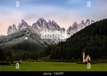 Die berühmte Kapelle von St. Johann in Ranui im Val di Funes (Dolomiten) mit dem jagge Gipfel der Geislergruppe Bereich im Hintergrund Stockfoto