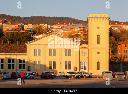 TRIESTE, 24. März 2019: Der Mann, der in einem roten Pullover steht vor der renovierten hydrodynamischen Power Station - jetzt Museum und Ausstellungshalle - Im n Stockfoto