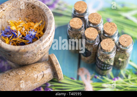 Getrocknete Heilkräuter im Glas auf dem Tisch mit Mörser und Stößel Stockfoto