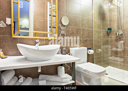 Modernes Interieur Badezimmer mit Waschbecken und Spiegel, Glas begehbare Dusche mit Marmor Fliesen Surround Stockfoto