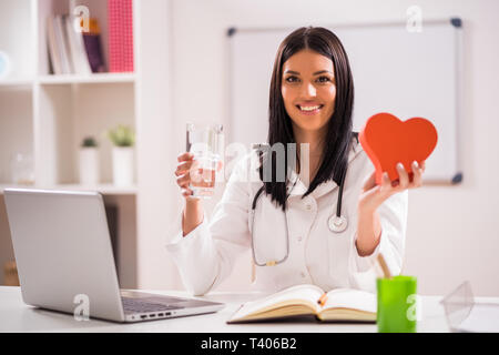 Junger Arzt in Ihrem Büro sprechen über die Gesundheit des Herzens. Stockfoto