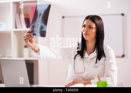 Junger Arzt prüft x-ray Bild in Ihrem Büro. Stockfoto