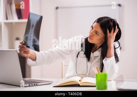 Junger Arzt prüft x-ray Bild in Ihrem Büro. Stockfoto