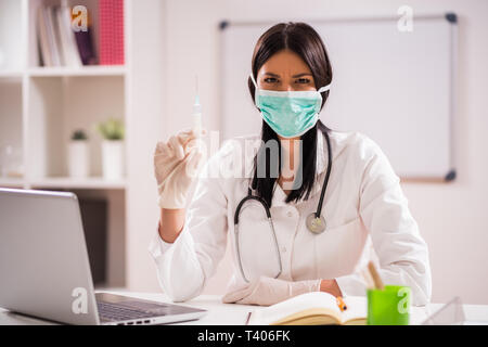 Junger Arzt spricht über die Bedeutung der Impfung. Stockfoto