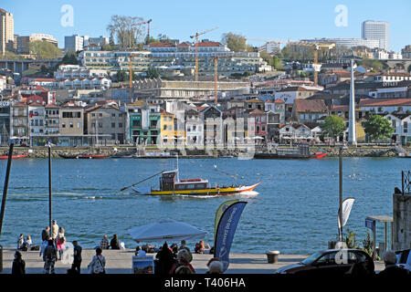 Ein Blick auf eine Bootsfahrt auf dem Douro Vila Nova de Gaia Häuser am Flussufer, Leute sitzen auf Ribeira Waterfront Quay Porto Portugal EU-KATHY DEWITT Stockfoto