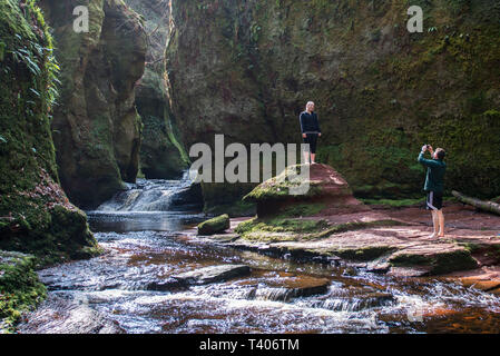 Menschen am Devils Kanzel in Finnich Glen und carnock Brennen, Stirlingshire Schottland. Stockfoto