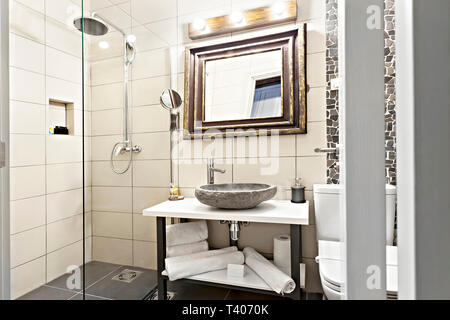 Modernes Interieur Badezimmer mit Waschbecken und Spiegel, Glas begehbare Dusche mit Marmor Fliesen Surround Stockfoto