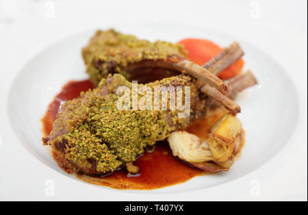 Gegrillter Lammrücken mit Minze und Pistazien auf Platte Stockfoto