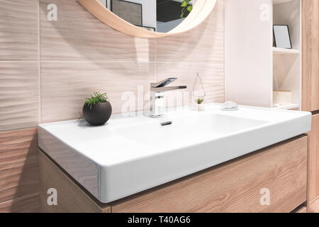 Luxus Wasserhahn Mischpult auf weiße rechteckige Waschbecken im Inneren des wunderschönen beige grau Bad. Stockfoto