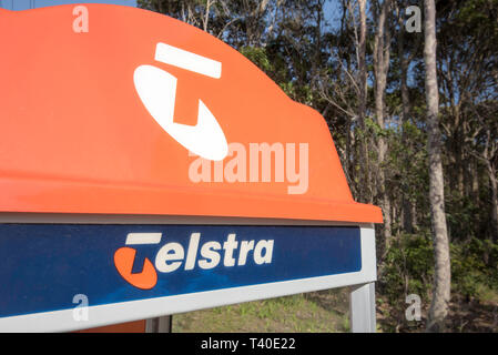 Die markante orange oben auf einem traditionellen Telstra öffentliche Telefonzelle auf einem Fußweg in einem ländlichen Dorf jetzt fast Redundante durch Mobiltelefone Stockfoto