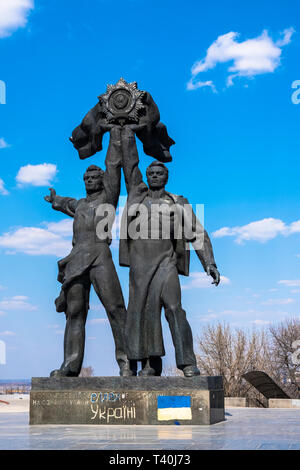 Bronzestatue, die einen Russischen und Ukrainischen Arbeiter halten der sowjetischen Ordnung der Freundschaft der Völker in der Nähe des People's Freundschaft Arch (Kiew/U Stockfoto