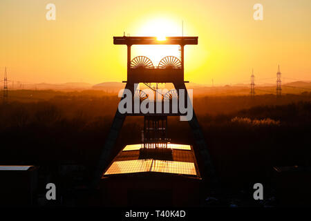 Herten, Ruhrgebiet, Nordrhein-Westfalen, Deutschland - Ewald Zeche, Doppelbock-Foerdergeruest über Welle 7 bei Sonnenuntergang, das Bergwerk geschlossen wurde Stockfoto