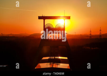 Herten, Ruhrgebiet, Nordrhein-Westfalen, Deutschland - Ewald Zeche, Doppelbock-Foerdergeruest über Welle 7 bei Sonnenuntergang, das Bergwerk geschlossen wurde Stockfoto