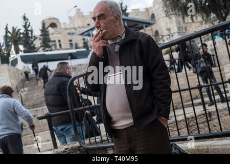 Das Rauchen einer Zigarette einen älteren Palästinensischen Mann nahe der Damaskus Tor in Ost Jerusalem, Israel, 15.03.19. Stockfoto