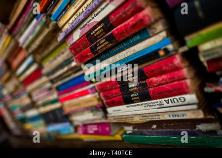 Stacheln von gebrauchten Bücher werden gesehen in eine gebrauchte Buchhandlung in San Salvador, El Salvador gestapelt. Stockfoto